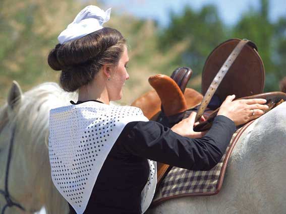 Affiche : "Reine d'Arles sellant son cheval Camargue" de Gilles MARTIN-RAGET
